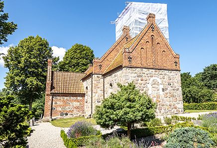 Kirken er opført i middelalderen, og ligger på en høj nord for landsbyen.